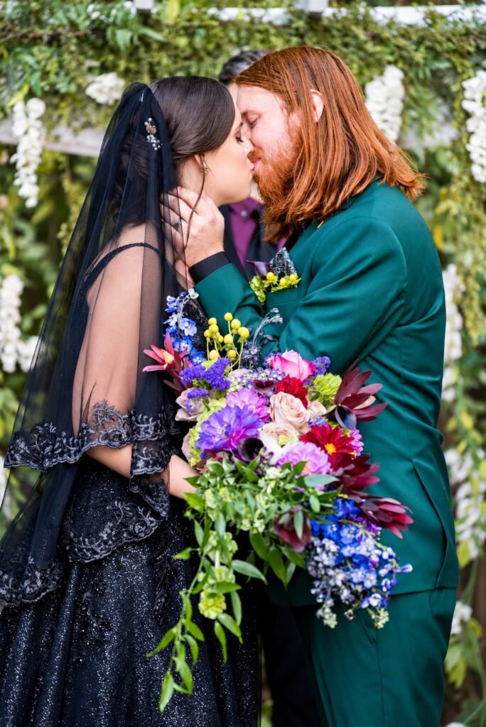 Close portrait of Parker and Olivia kissing with a colorful bouquet