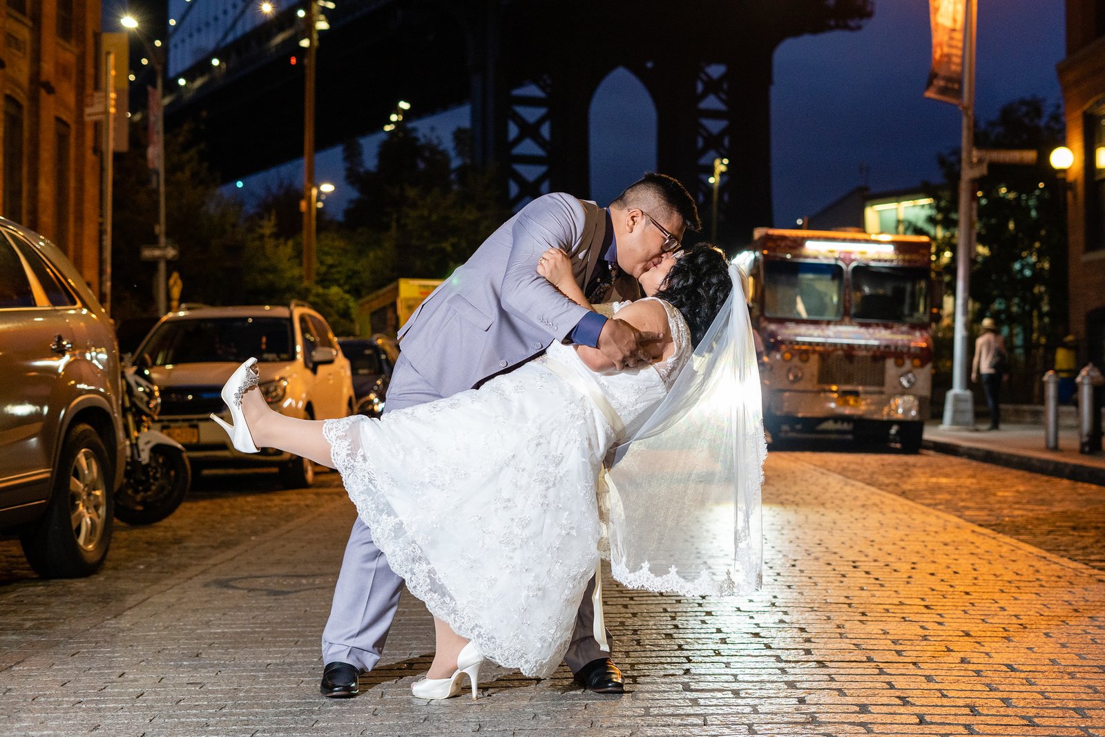 David dips Brenda for a kiss on an illuminated street.