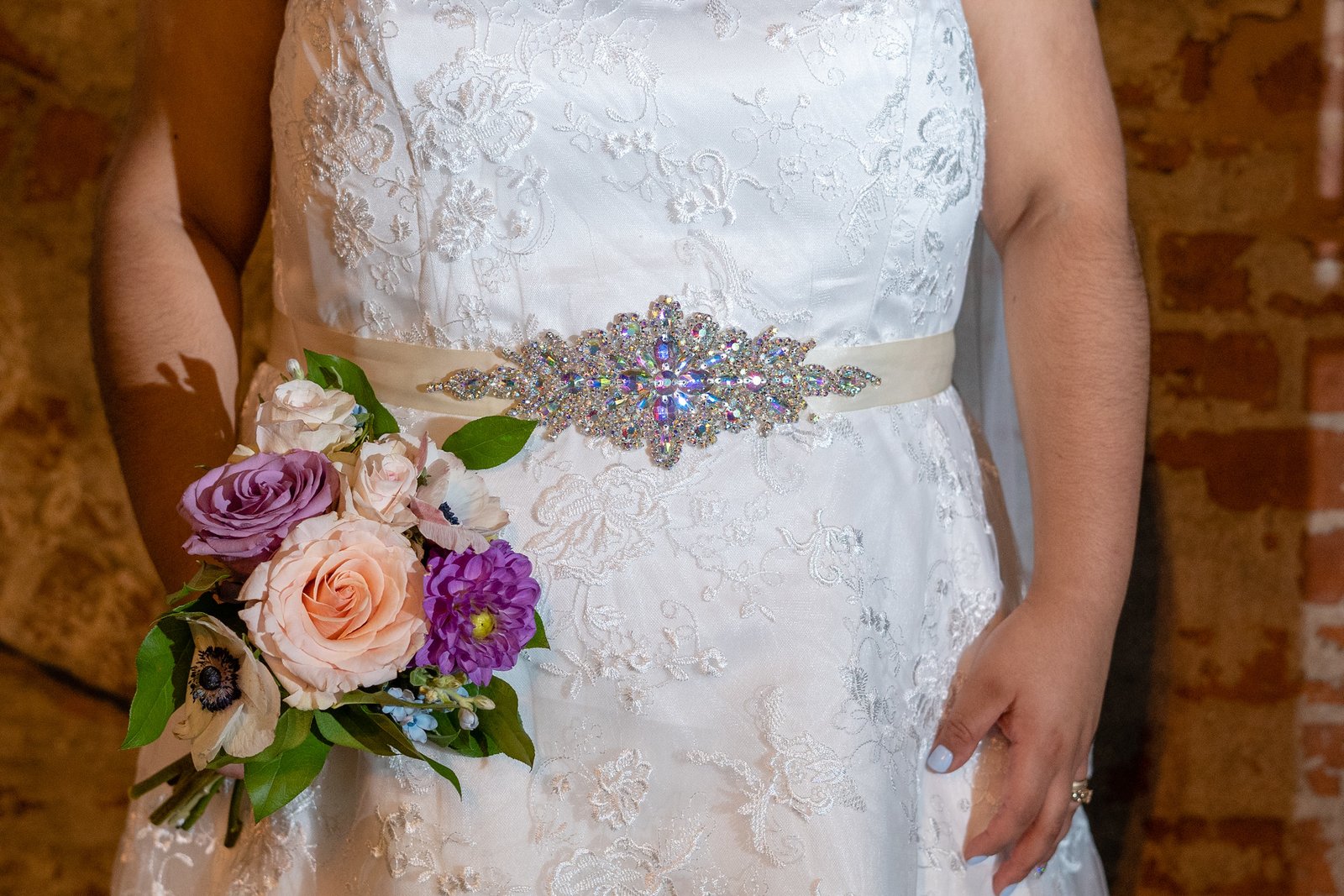 A close view of Brenda's bouquet, dress and beaded belt.