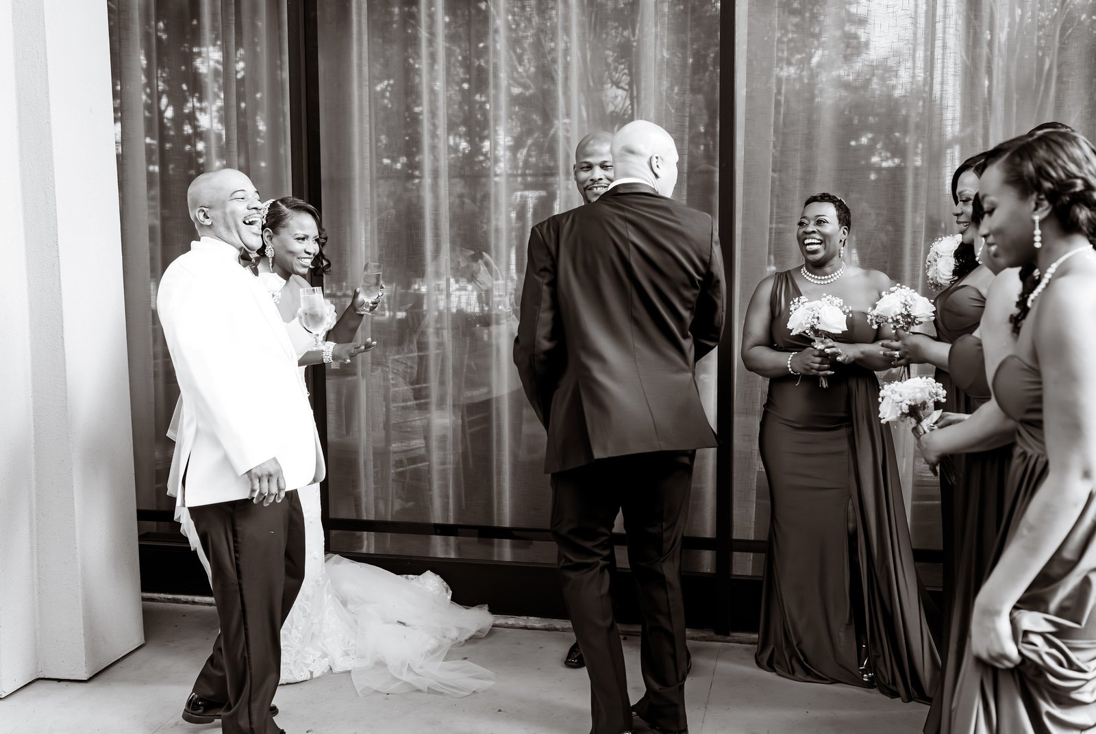 The newlyweds laughing with their wedding party after the ceremony.