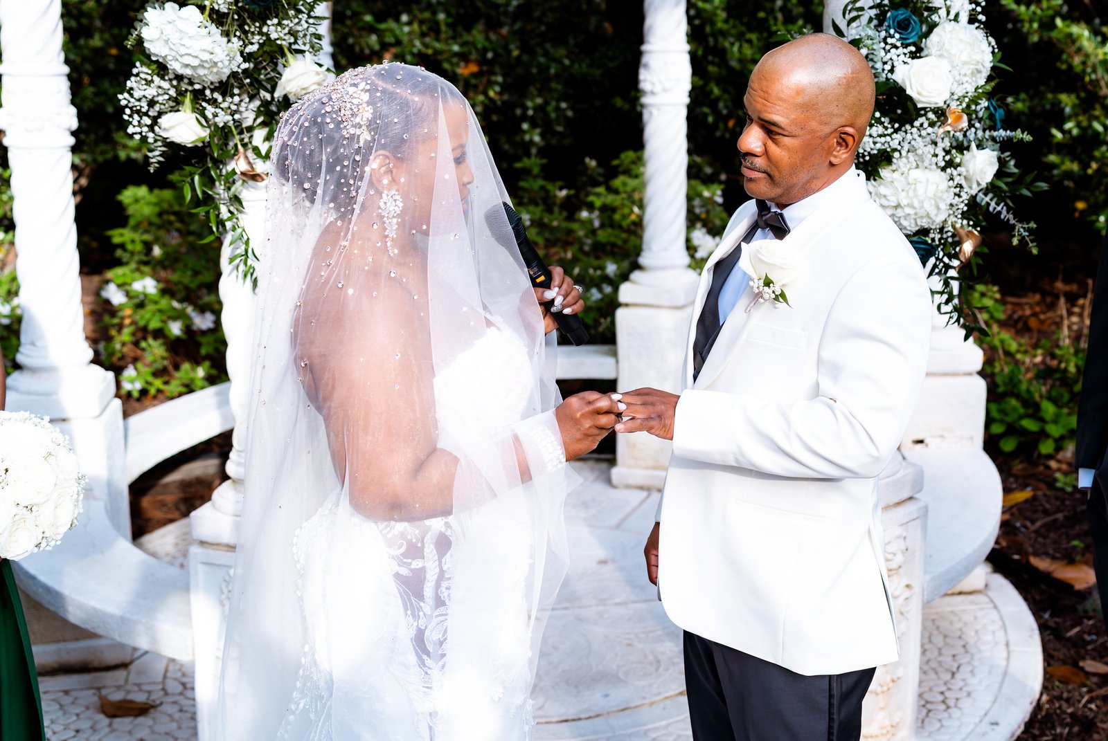 The bride placing a ring on the groom's hand during the ceremony.