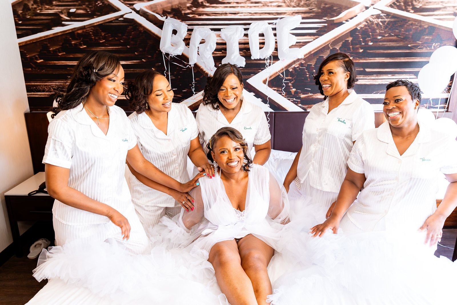 The bride laughing with her wedding party while getting ready.