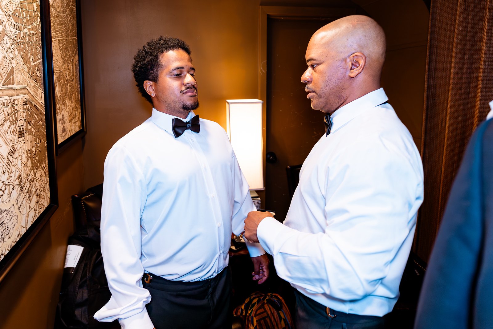 Two members of the wedding party adjusting a shirt cuff.