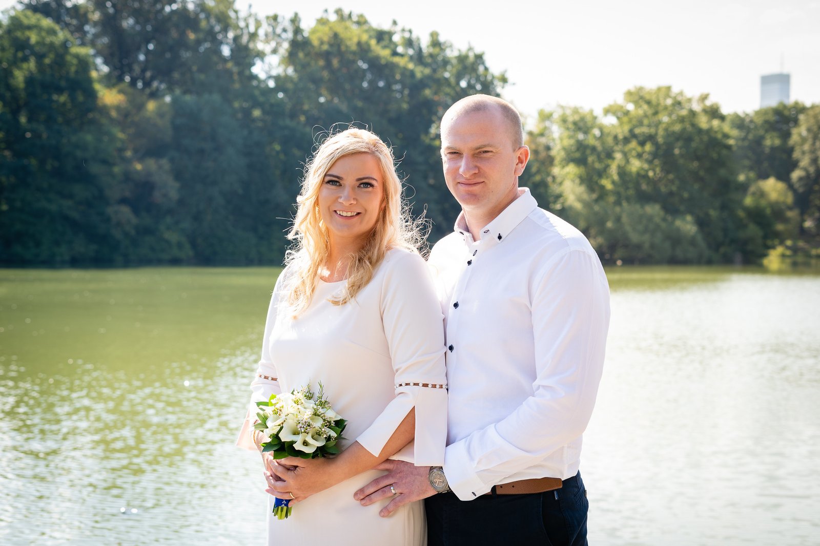 Mary and Shamus stand together beside the water.