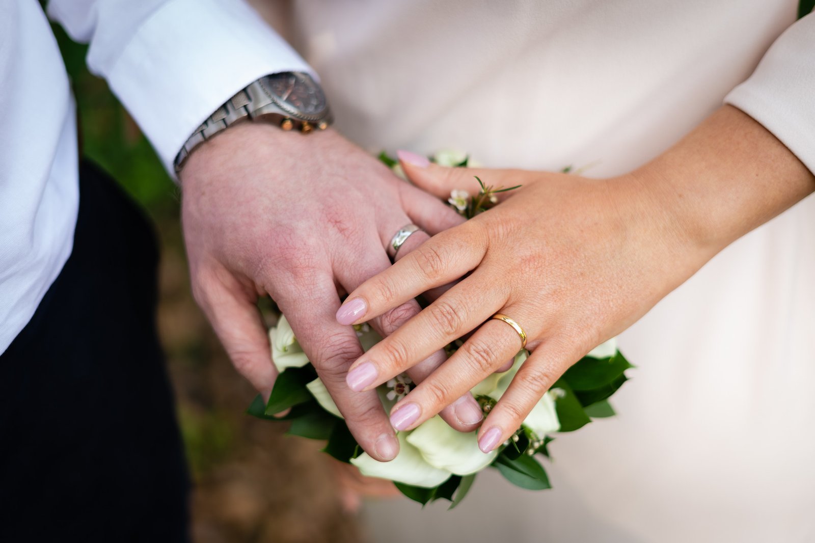 The couple's hands together, showing their wedding rings.