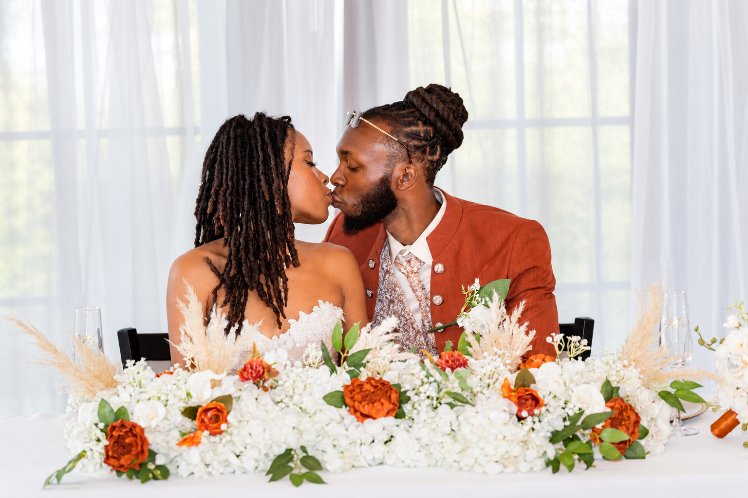 Newlywed sweetheart table kiss at Burnett and Jaelyn's wedding