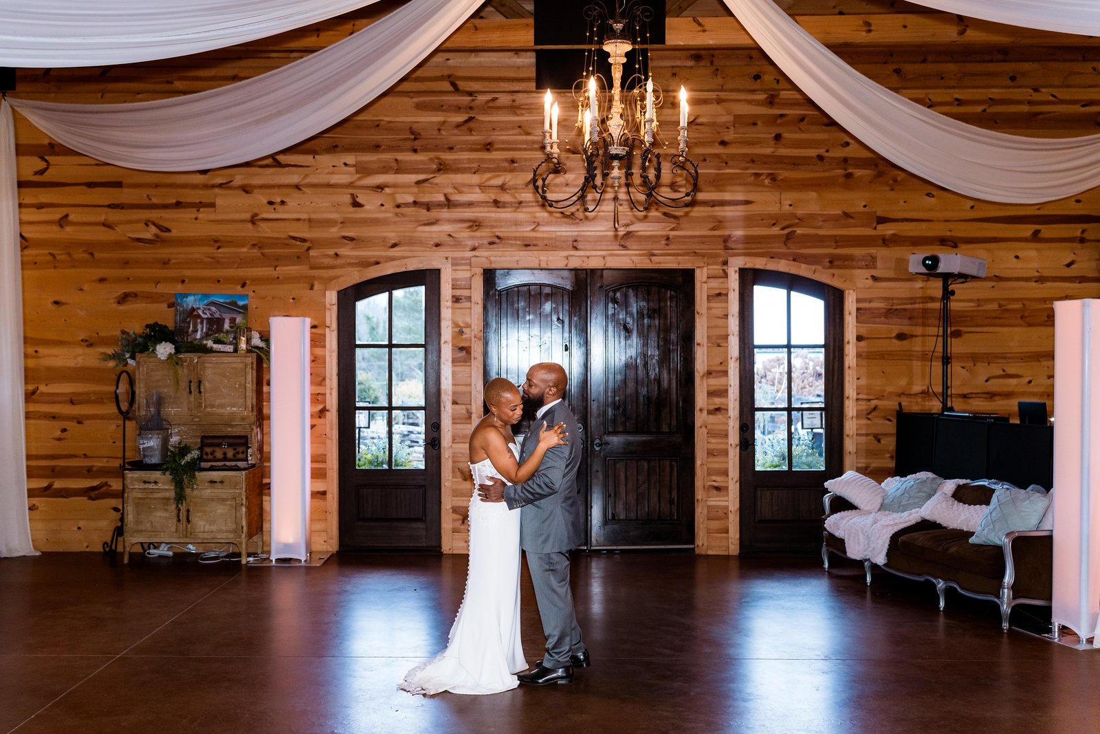 Maurice and Jillian dance beneath a chandelier in the timber reception room