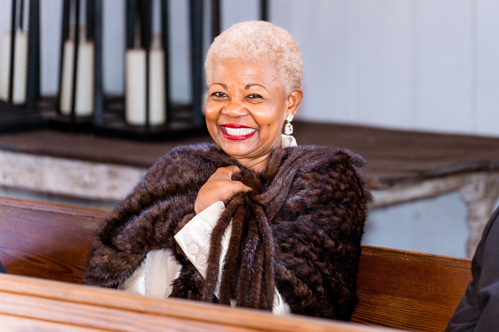 A smiling guest watches the wedding ceremony