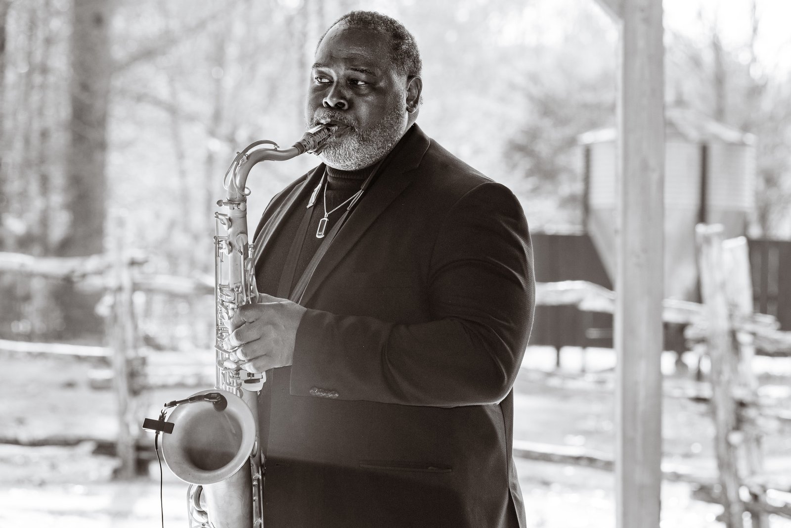 A saxophonist plays during the wedding in black and white