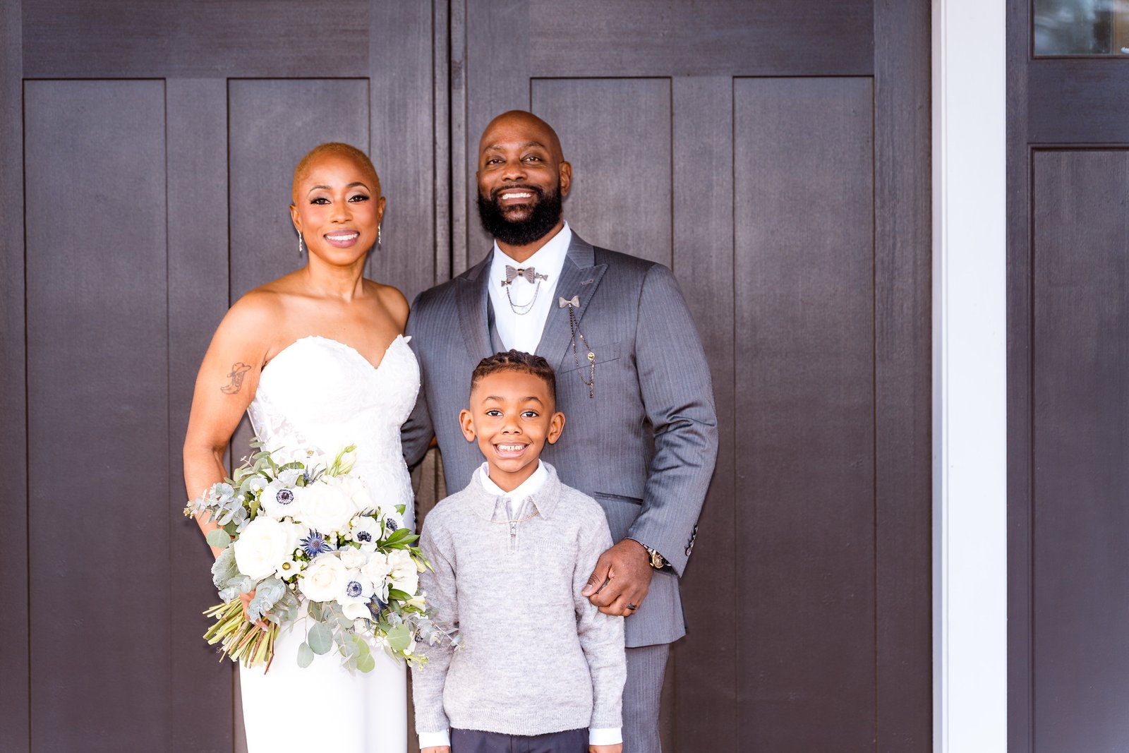 Maurice and Jillian smile with a young wedding guest