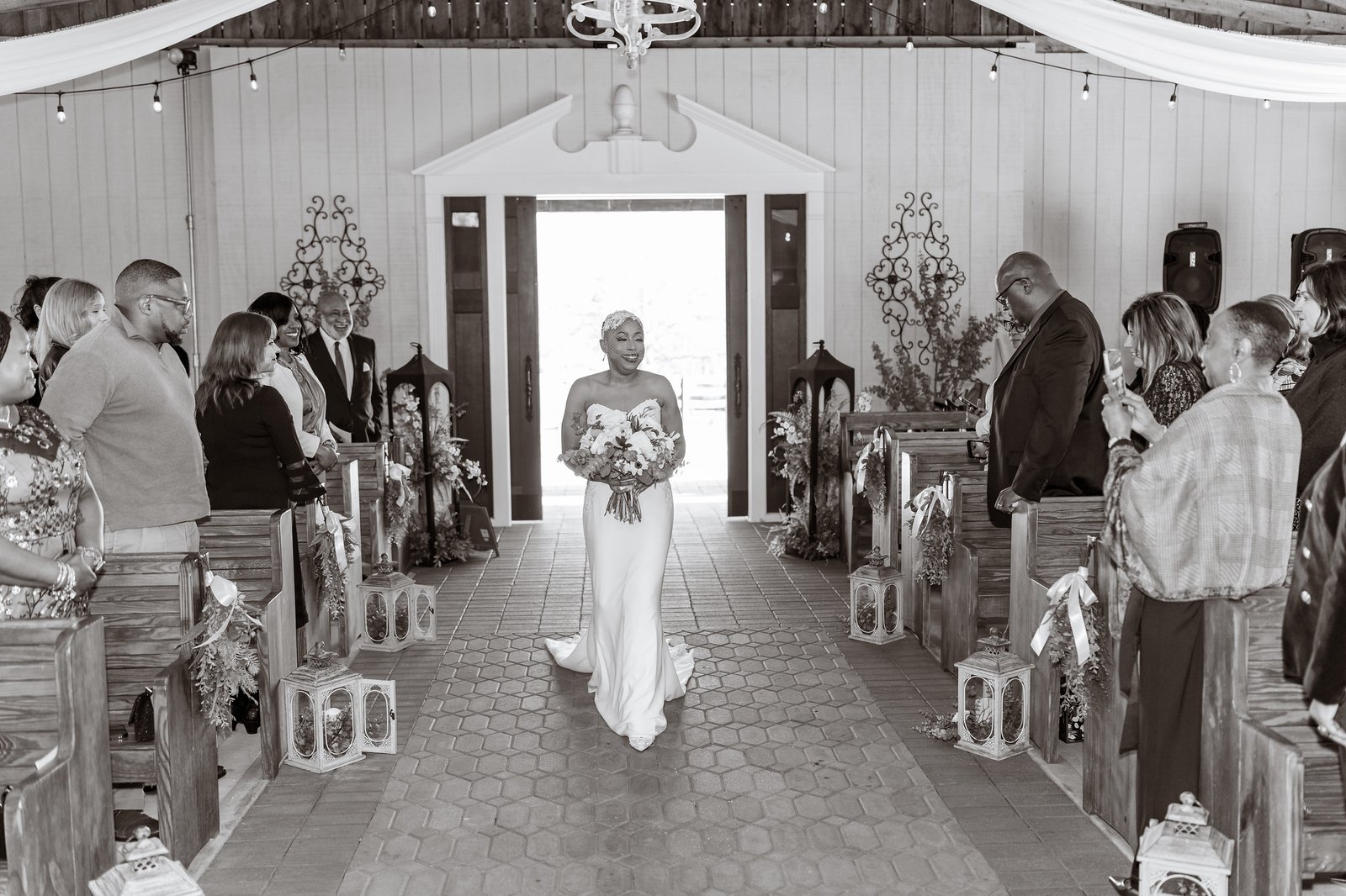 Jillian walks down the aisle as guests stand around her