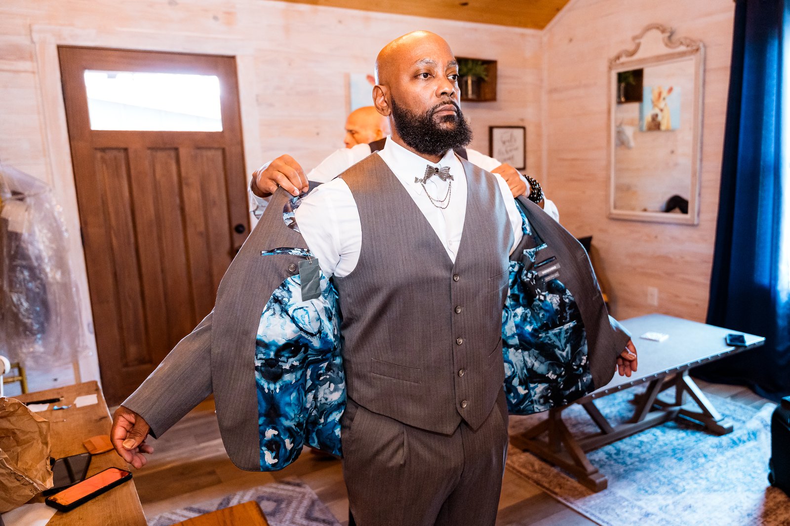 Maurice puts on his wedding jacket with help from a friend