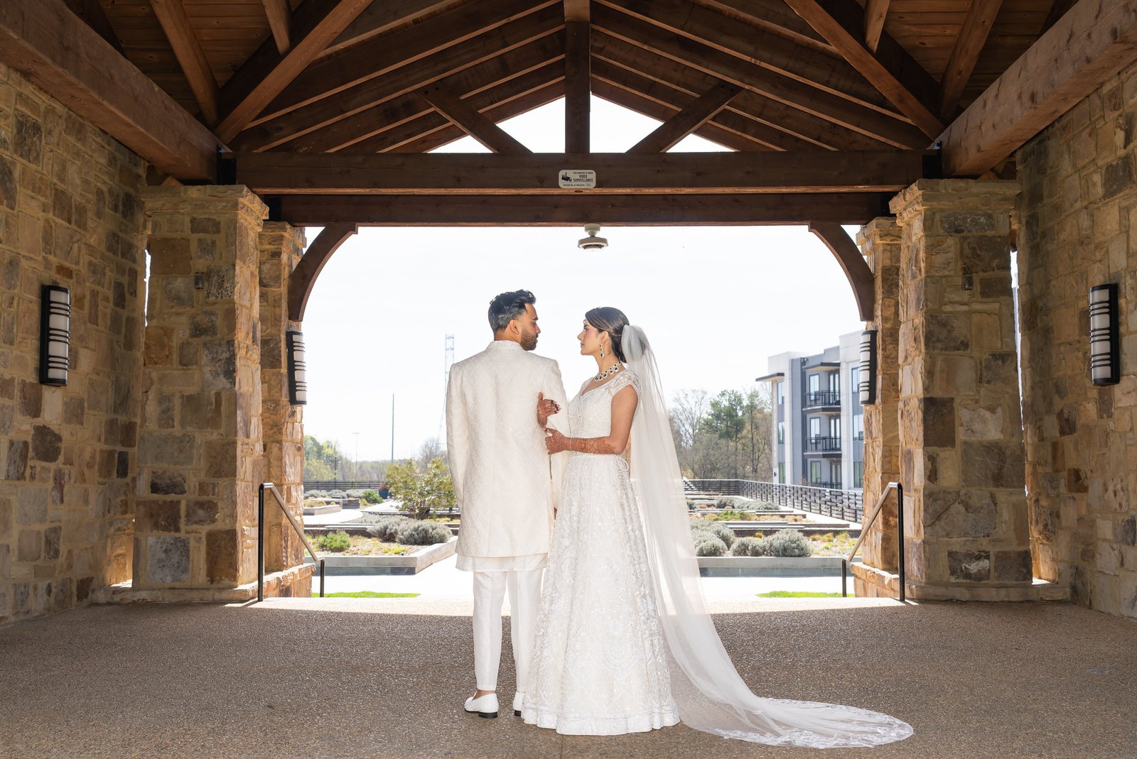 Mehreen and Shahzain beneath a timber and stone portico