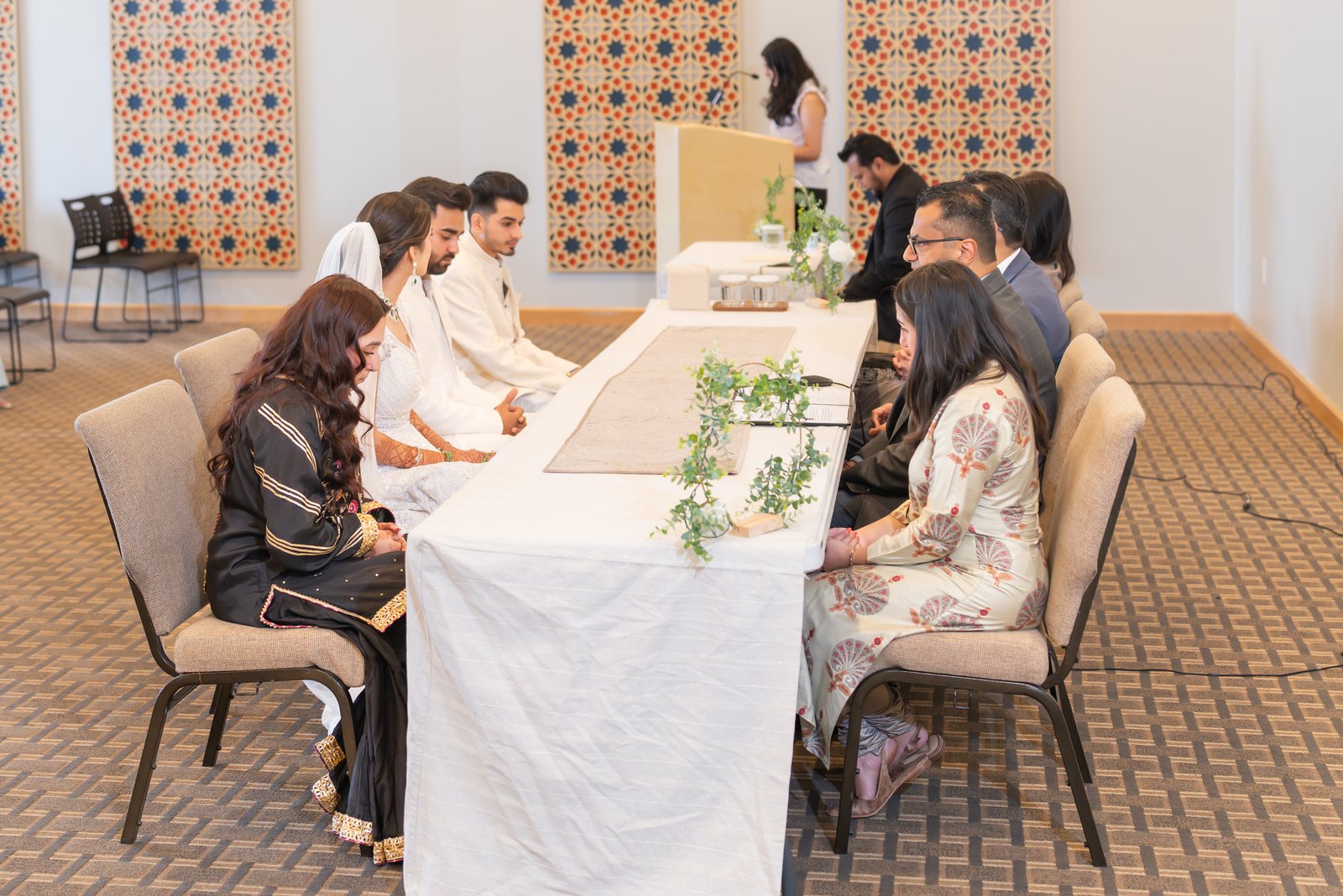 Mehreen and Shahzain seated with family during their ceremony