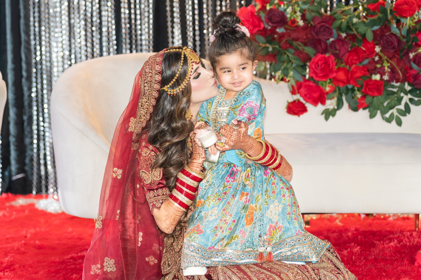 Mehreen kisses a smiling child on the cheek