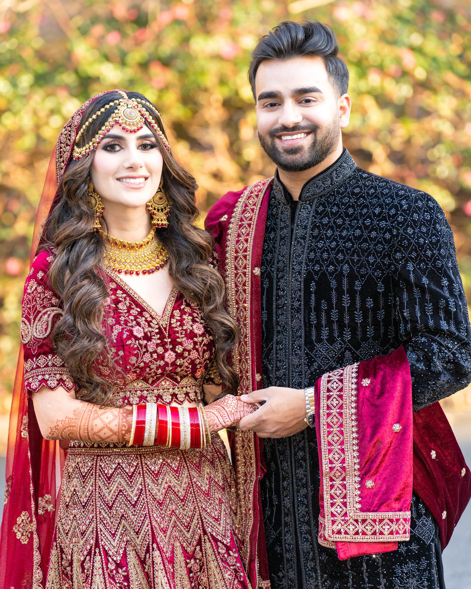 Mehreen and Shahzain smile in their red and black reception attire
