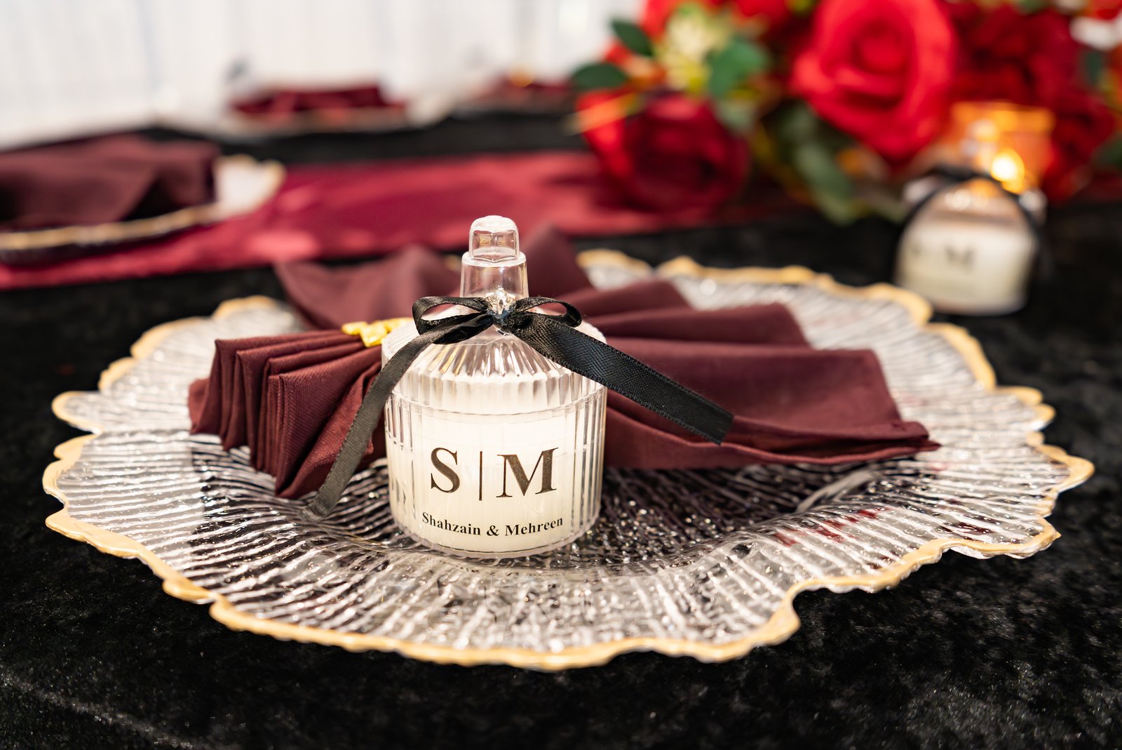 A personalized wedding favor at a burgundy and gold place setting