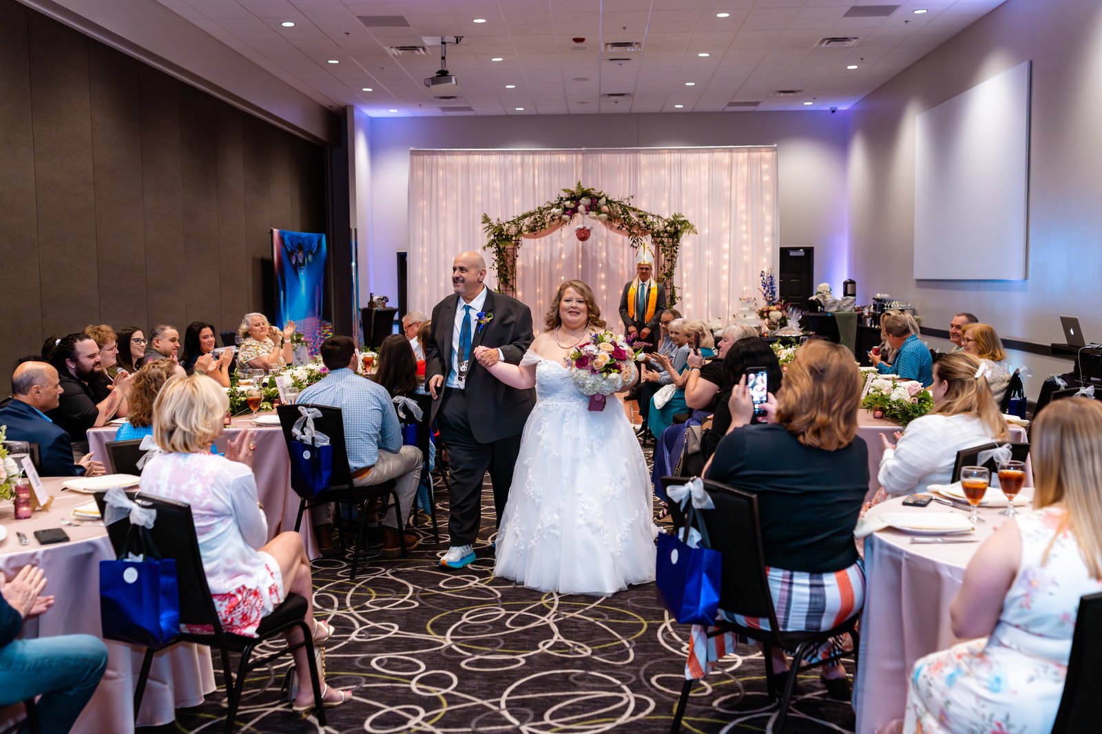 The newlyweds walk down the aisle among their guests