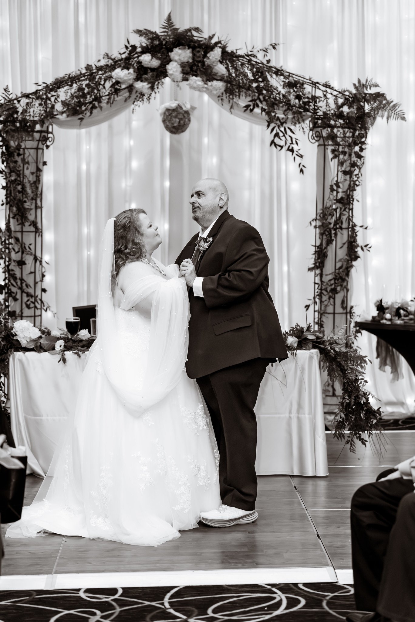 Black-and-white photograph of the first dance beneath the arch