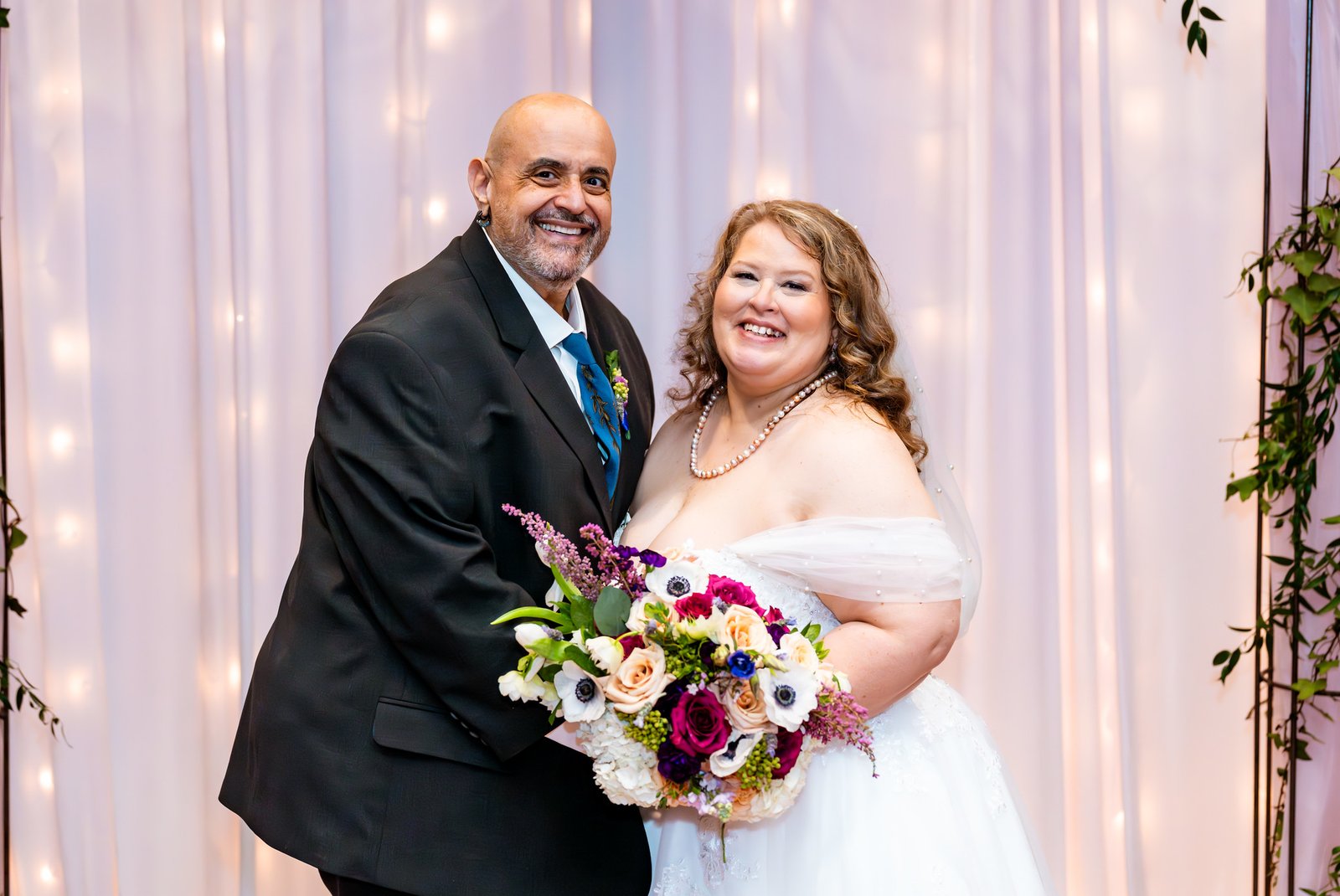 Noris and Towanna smile together holding the bridal bouquet