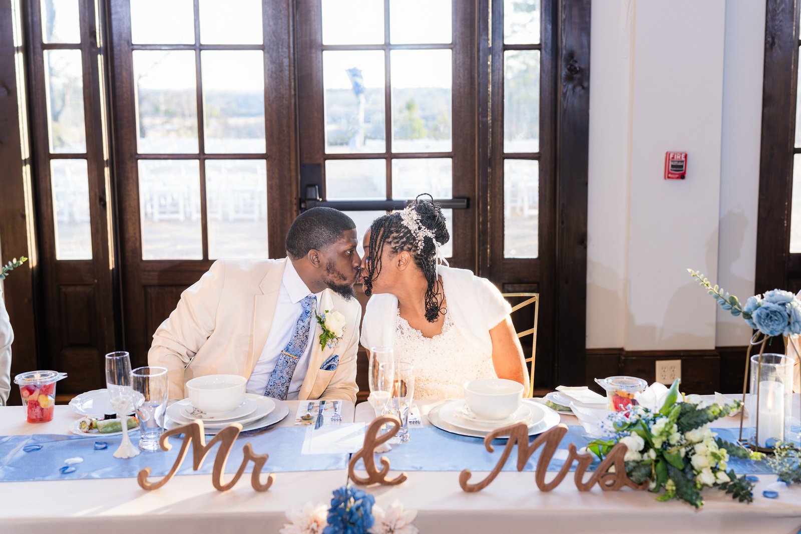 Tanjana and Marcel share a kiss at their reception table