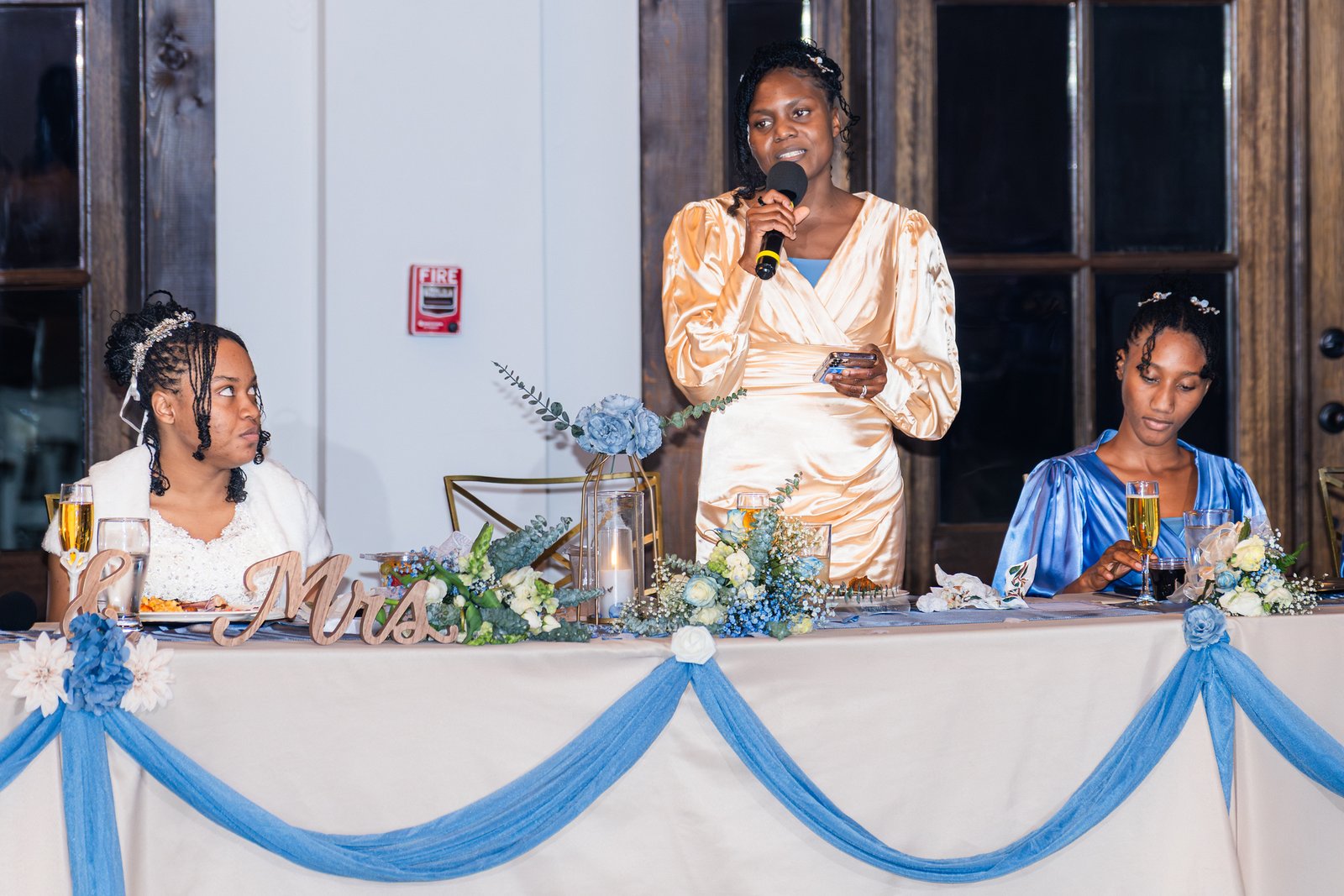 A wedding guest gives a speech beside Tanjana