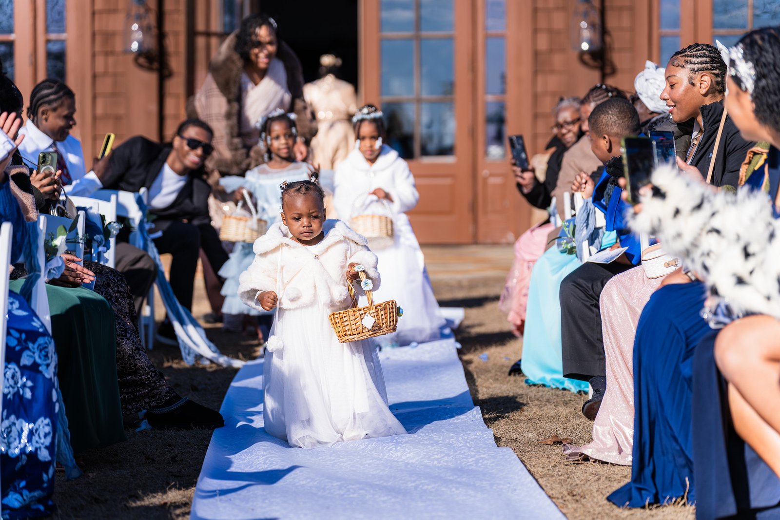 Flower children walk down the blue ceremony aisle