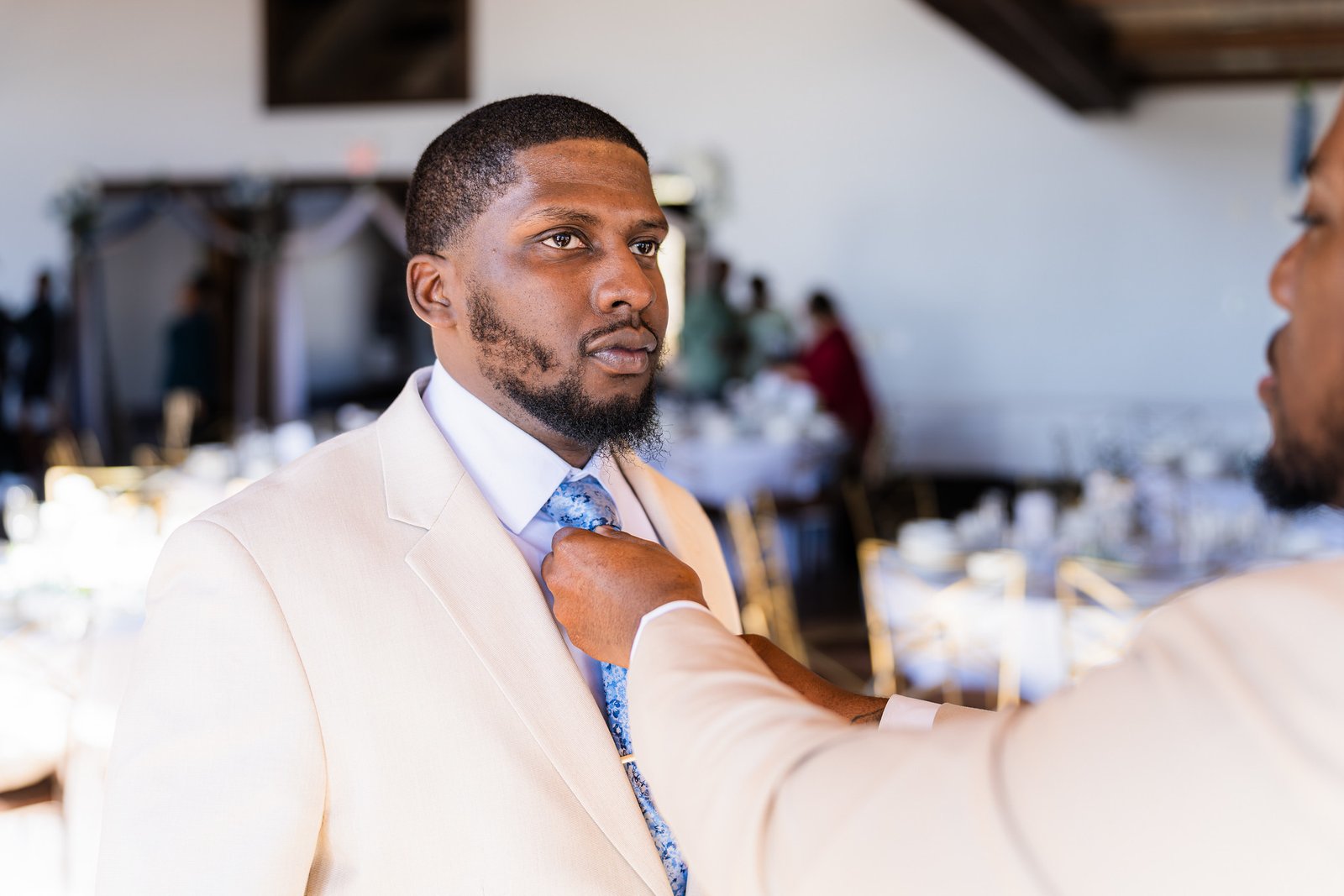 Marcel's tie is adjusted before the ceremony