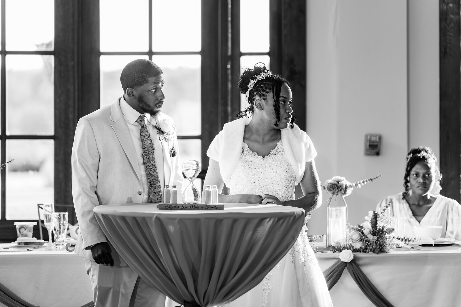 Tanjana and Marcel listen together during the reception in black and white