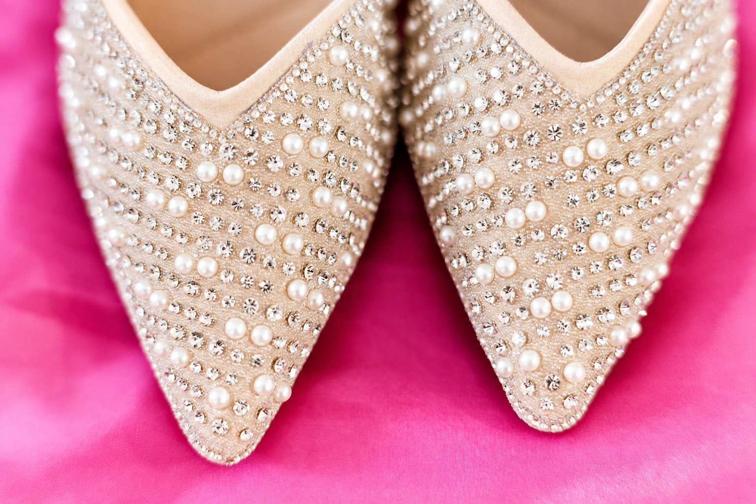 Pearl embellished bridal shoes on pink fabric