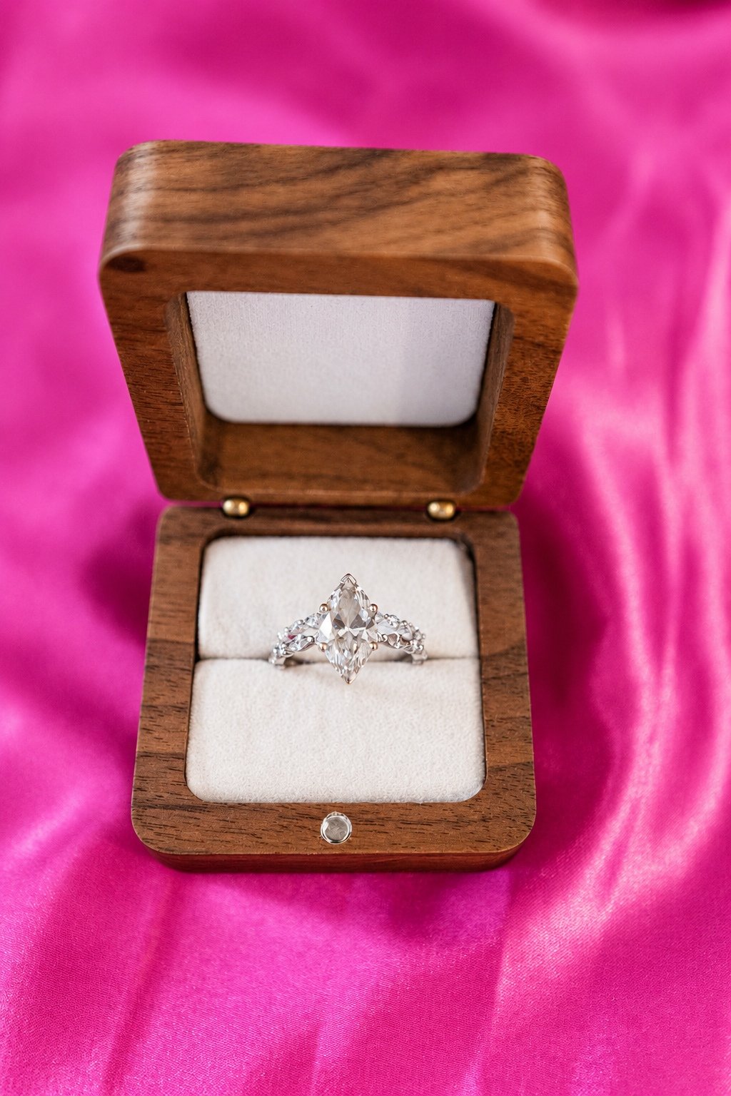 Wedding rings in a wooden box on pink fabric