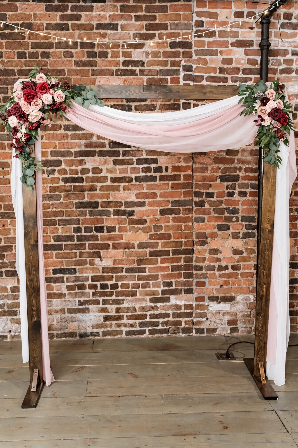 Pink draping and flowers against Boxwood’s exposed brick