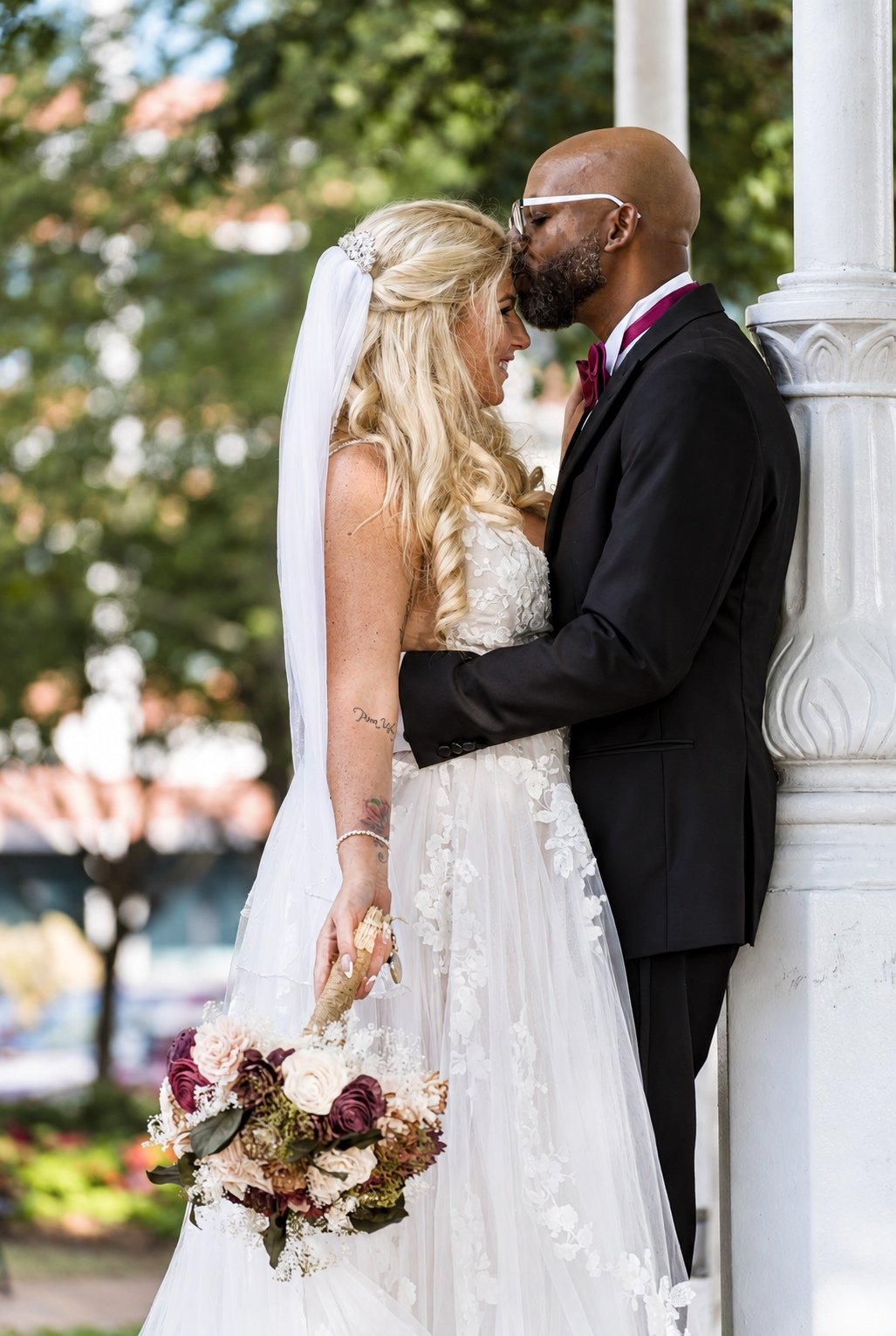 Franz kissing Mikayla’s forehead beside the gazebo
