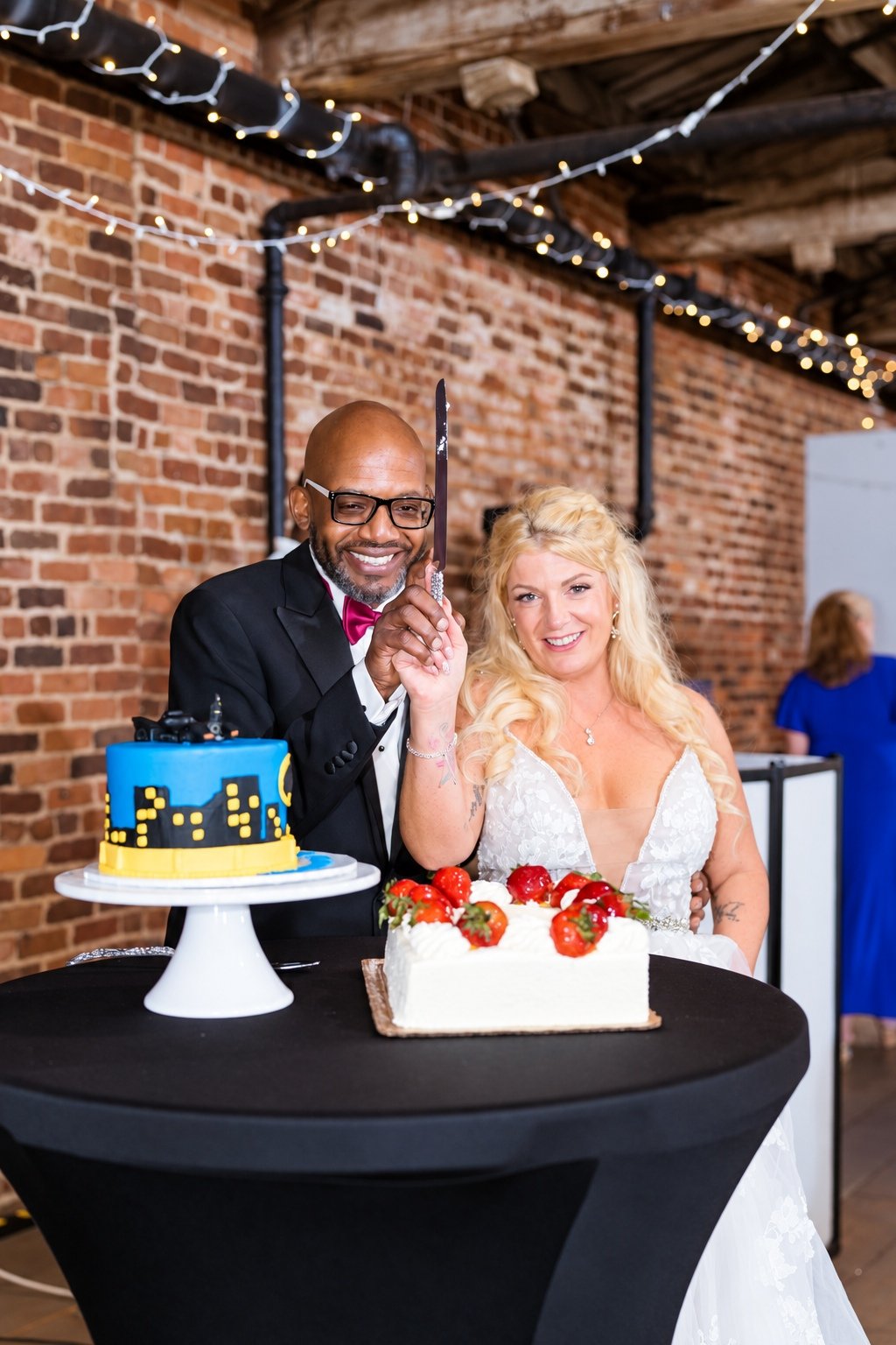 Franz and Mikayla celebrating beside their wedding cake
