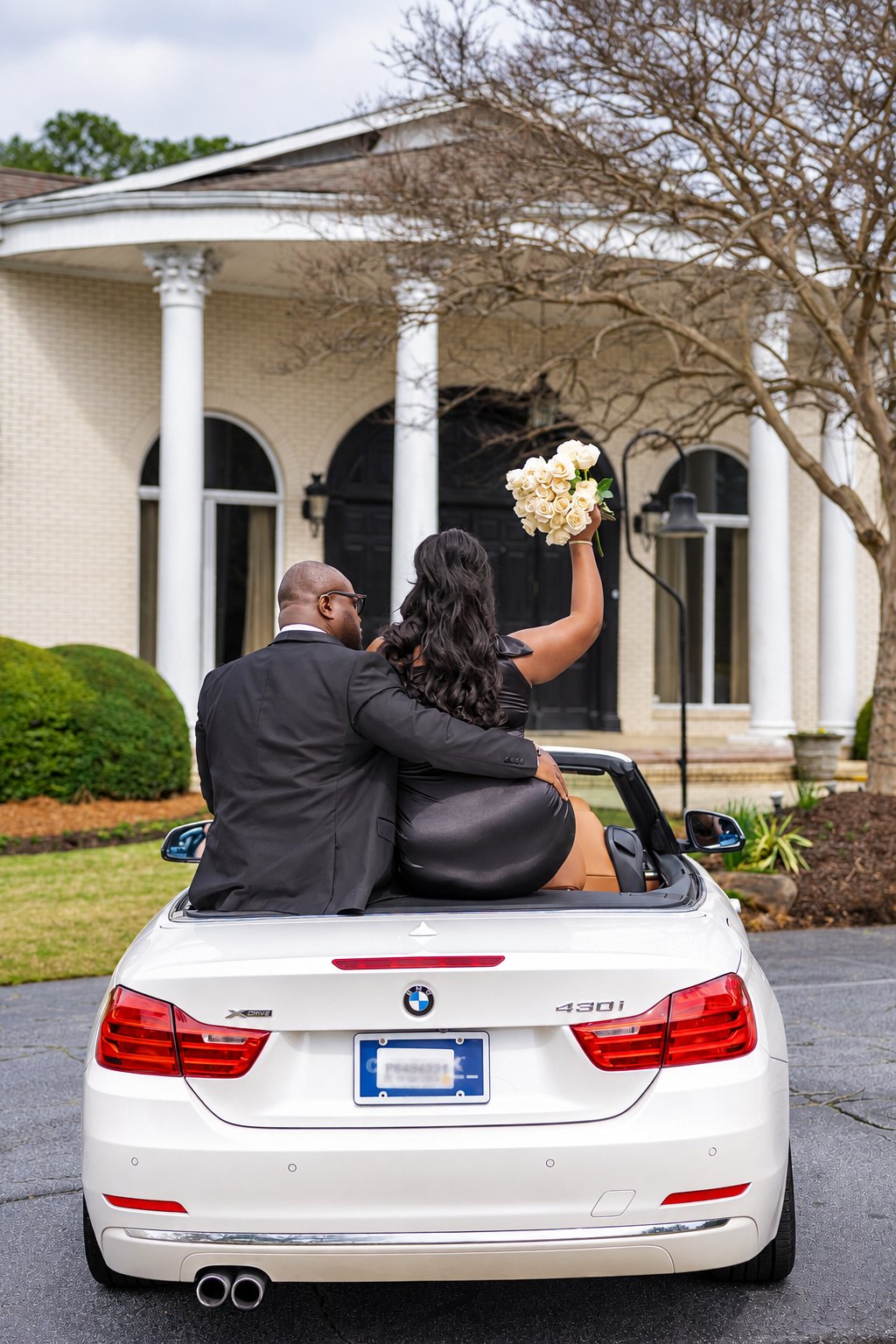 Couple with ivory roses at the back of the convertible