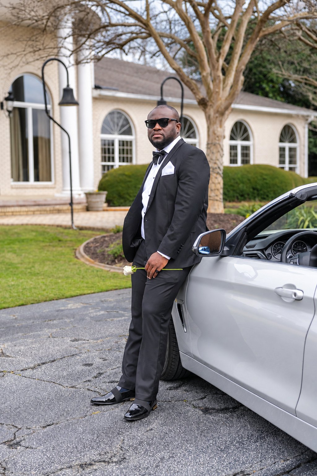 Kobina in black formalwear with a white rose