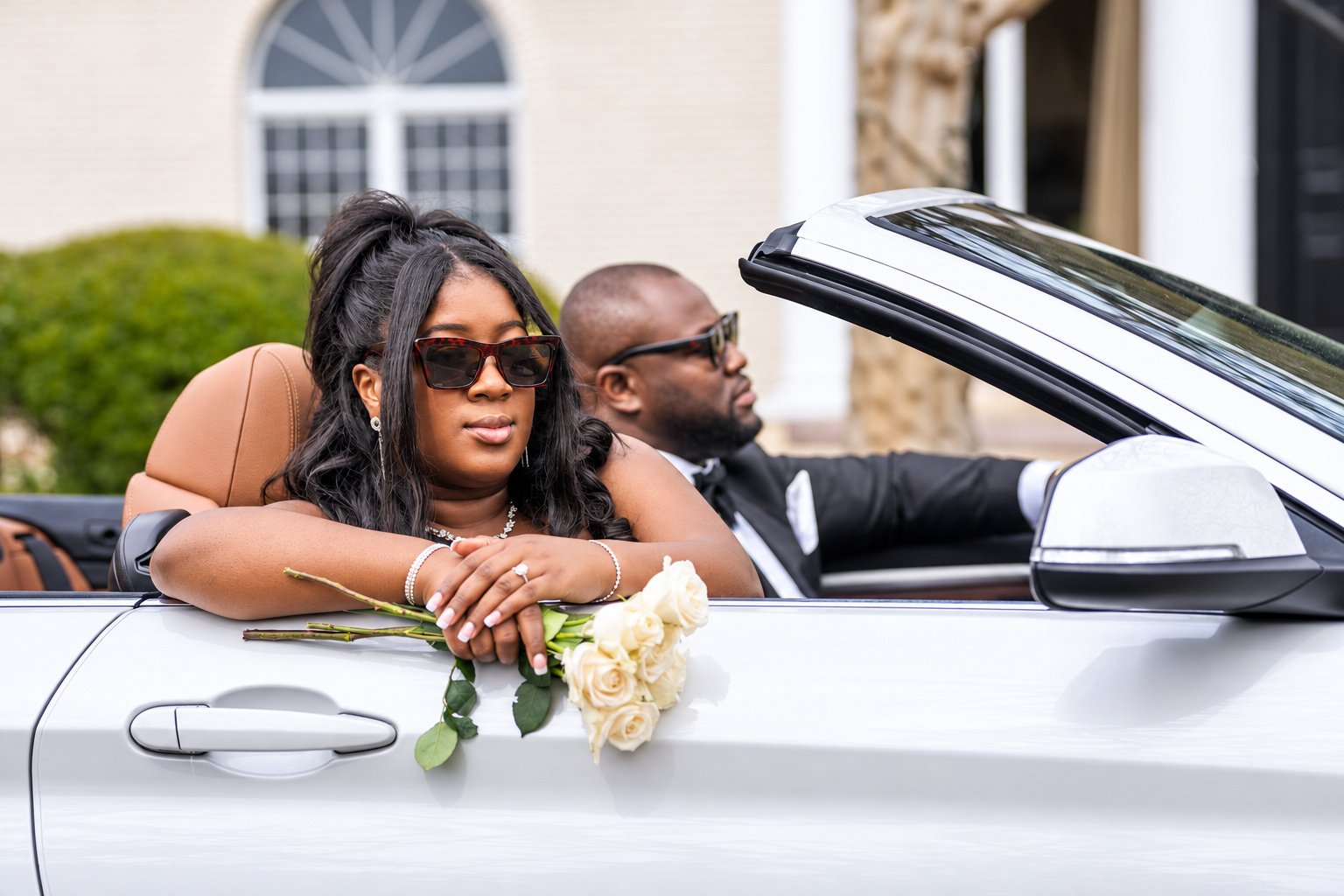 Tiara wearing sunglasses beside the convertible