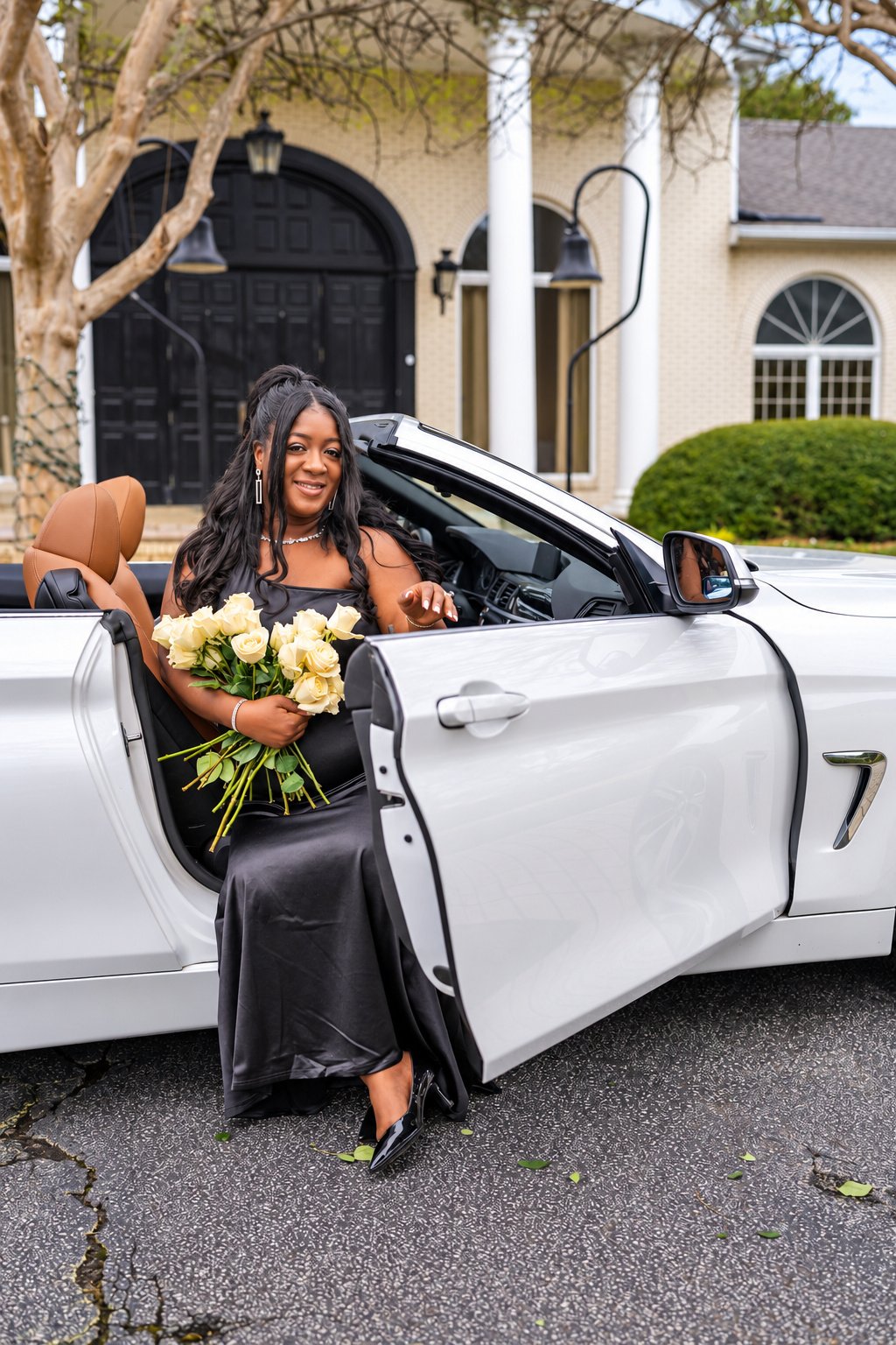 Tiara seated beside the open car door with ivory flowers