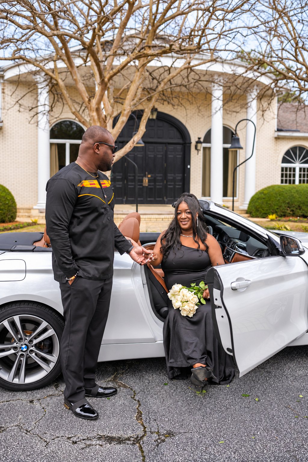 Kobina holding Tiara’s hand beside the car