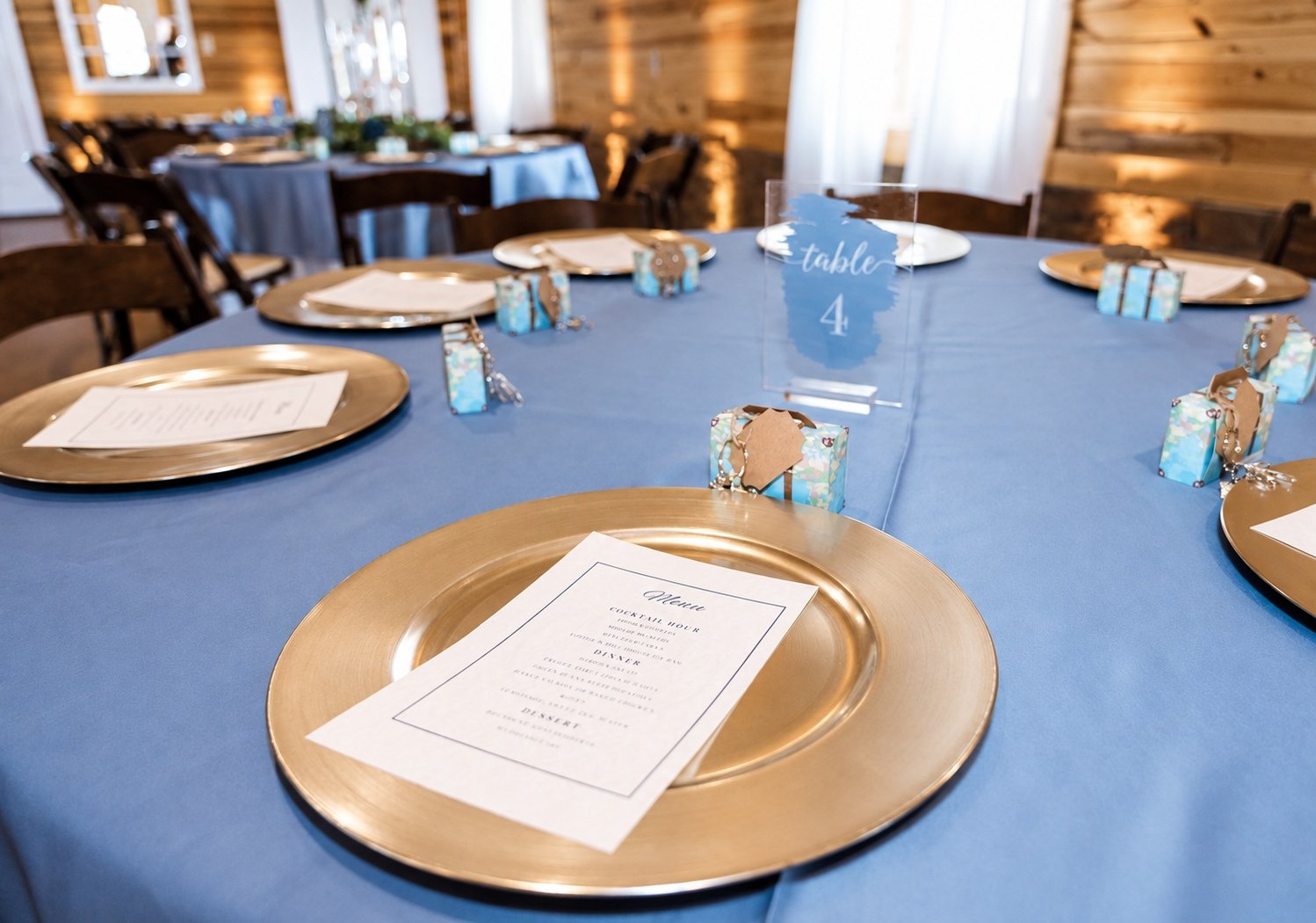 Blue table linen and a gold charger at the wedding reception