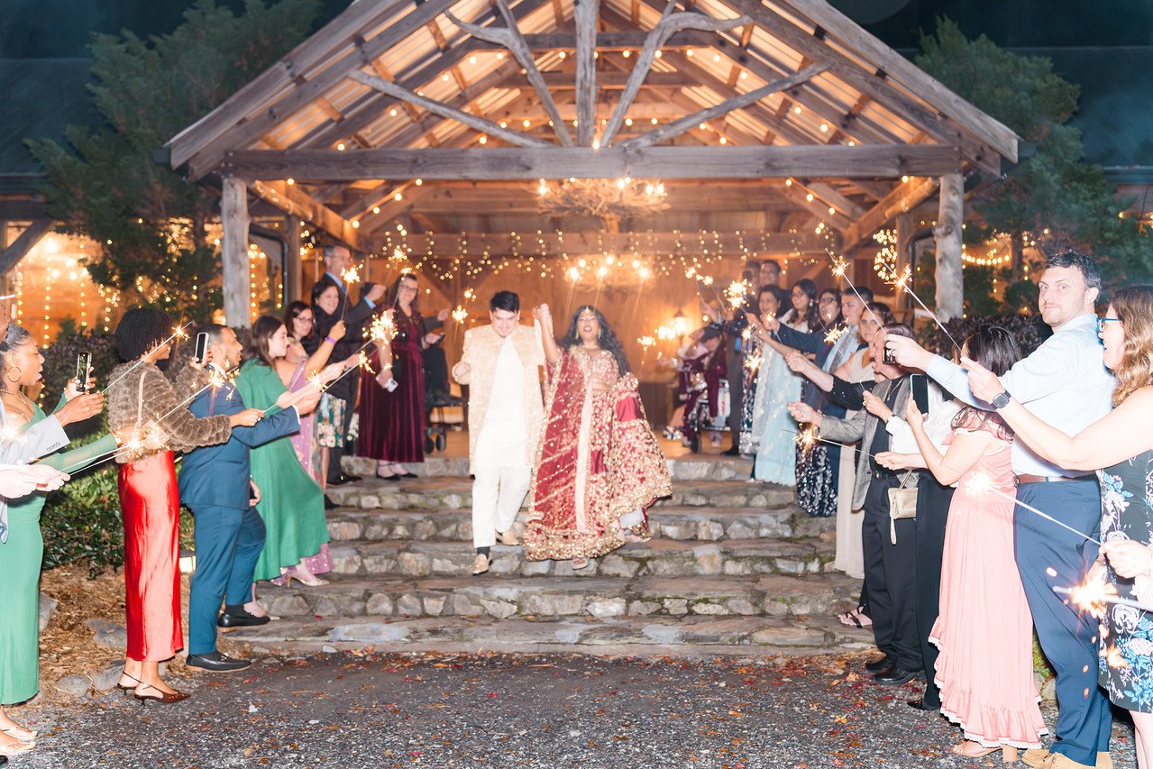 Guests surround Reeham and Logan with sparklers outside the reception barn