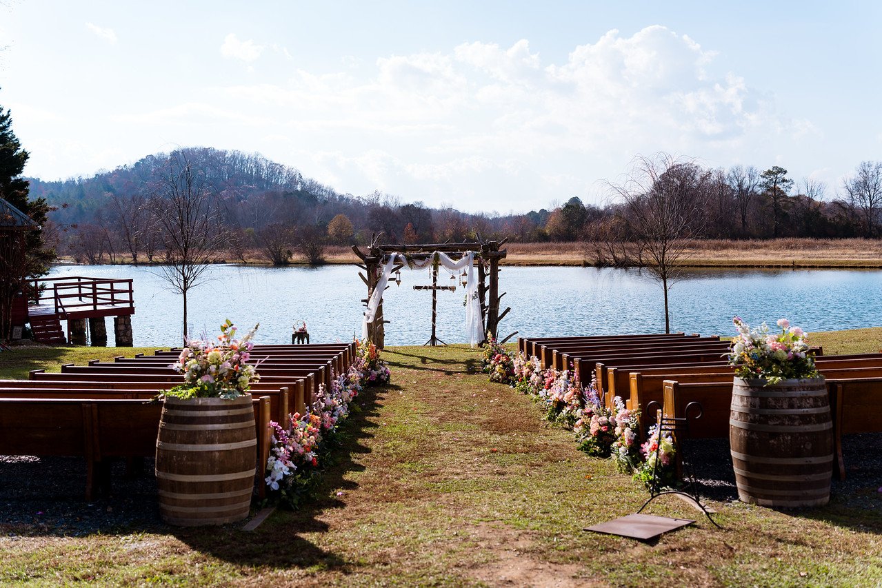 Lakeside wedding ceremony aisle and wooden arbor at Spring Lake Events