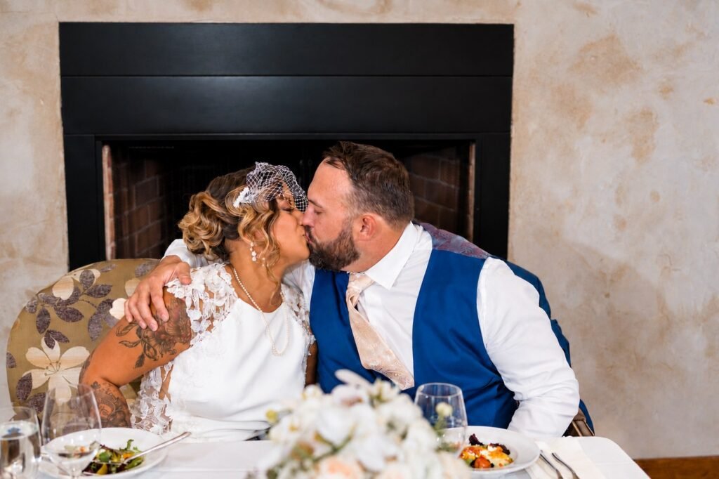 Couple kissing at their reception table at Montaluce Winery in Dahlonega, Georgia.